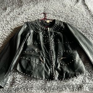 Black leather jacket withrivets.Detailed zipper pulls on pockets.